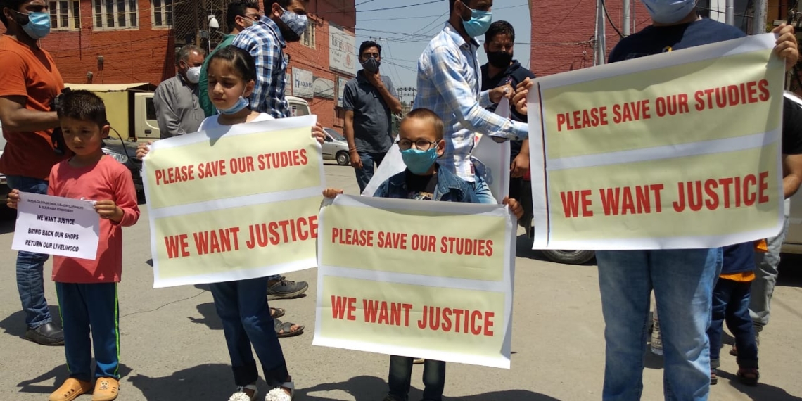 Shopkeepers protest along with their children after their shops handed over to ex-service men