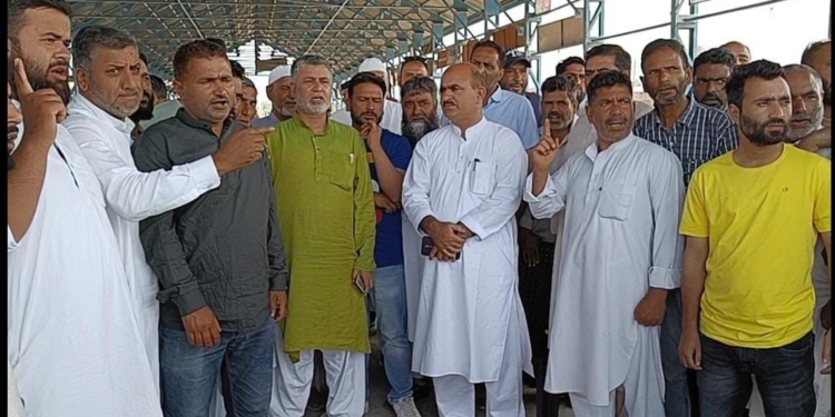 Fruit growers and dealers protest at Sopore fruit mandi over halting of trucks on NH-44